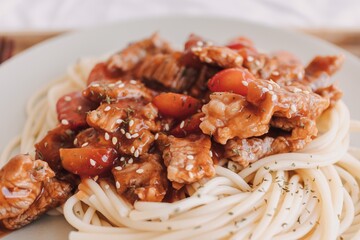Homemade Beef Spaghetti with sauce served on white dish.