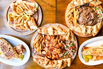 Traditional Turkish cuisine. Pizza, pita, pidesi, sucuk, hummus, kebab. Many dishes on the table. Serving dishes in restaurant. Background image. Top view, flat lay