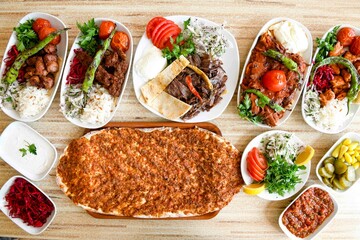 Traditional Turkish cuisine. Pizza, pita, pidesi, sucuk, hummus, kebab. Many dishes on the table. Serving dishes in restaurant. Background image. Top view, flat lay