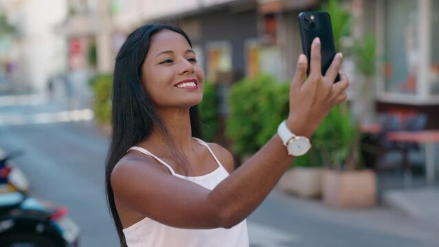 Young beautiful woman smiling confident making selfie by the smartphone at street