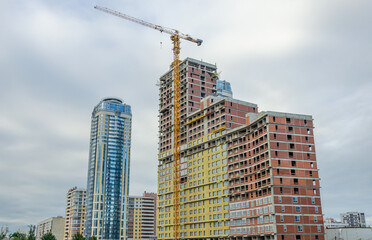 Fototapeta na wymiar Construction of a high-rise building using a tower crane