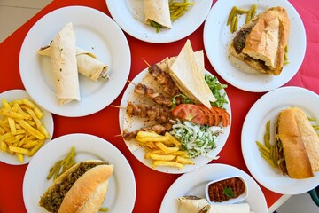 Delicious meat kebab with fresh vegetable salad served with variety of Turkish dishes and appetizers. Top view of assorted Turkish food and meze, tasty and healthy Mediterranean cuisine.