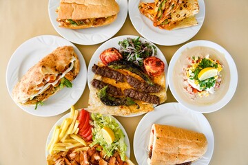 Delicious meat kebab with fresh vegetable salad served with variety of Turkish dishes and appetizers. Top view of assorted Turkish food and meze, tasty and healthy Mediterranean cuisine.