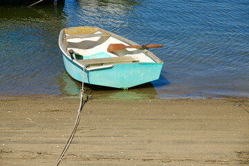 blue row boat beached on the bay