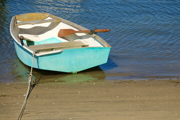 Naklejka premium classic wood rowboat floating on the bay