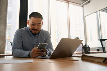 Joyous young employee working in company office