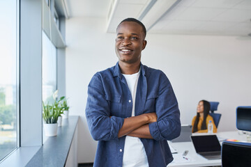 Naklejka na ściany i meble Portrait of happy African American man standing at startup office