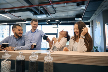 Joyous young corporate workers enjoying coffee break