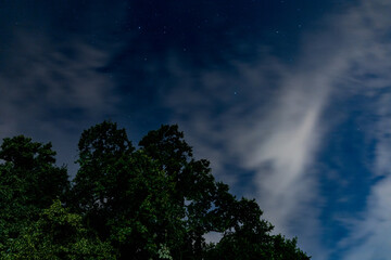 Dark blue sky on long exposure with moving clouds at night