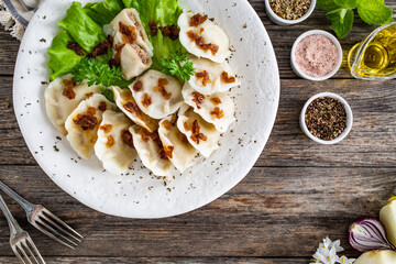 Dumplings - meat dumplings with onion and bacon on  wooden table
