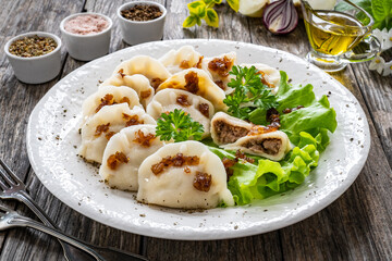Dumplings - meat dumplings with onion and bacon on  wooden table
