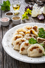 Dumplings - meat dumplings with onion and bacon on  wooden table
