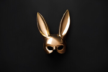 Halloween background with gold bunny mask decor. Top view with copy space. Minimalism. Halloween concept Gold mask on black background.