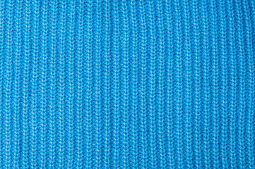 The texture of a knitted wool sweater in blue.