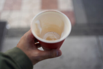 Man hand holding an empty take away paper coffee cup