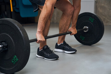 Cropped view of the fitness deadlift man bodybuilding at loft health club