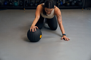 Naklejka premium Girl standing at the knees while exercising using a ball at the loft place interior