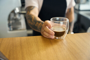 Professional coffee shop worker presenting fresh espresso