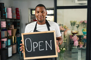 Florist shop with a signboard in his hands