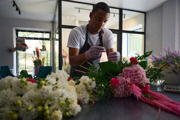 Guy concentrated on collecting a bouquet on the table
