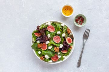 Portion of fig, salad leaves, feta and walnuts salad