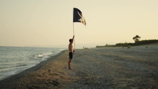 Boy waving pirate flag on a desert island