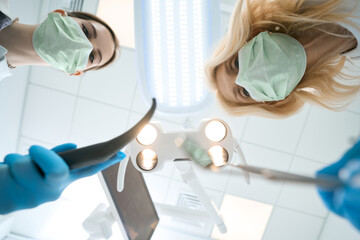 Dentist and assistant preparing to treat patient