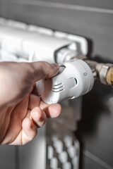 Hand regulating the radiator temperature with a thermostatic head, selective focus