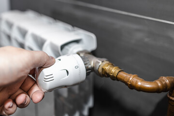 Hand regulating the radiator temperature with a thermostatic head, selective focus