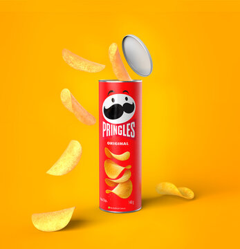 Malaga, Spain - September 24, 2022: Open package of Pringles potato chips on yellow background. Crispy fries
