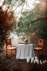 Romantic candlelit dinner in the autumn forest for lovers. High quality photo