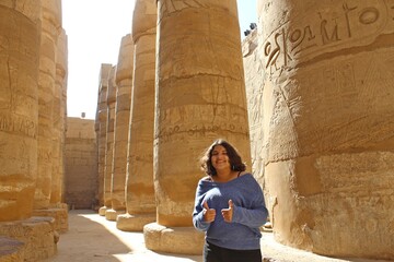 Beautiful teen girl in front of  columns  in row in Karnak temple in Luxor in Egypt