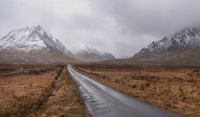 Dark and moody Winter landscape image of Lost Valley Etive Mor in Scottish Highlands wirth dramatic clouds overhead