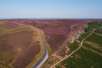 Stunning vibrant late Summer aerial drone landscape image of heather in full bloom in Peak District