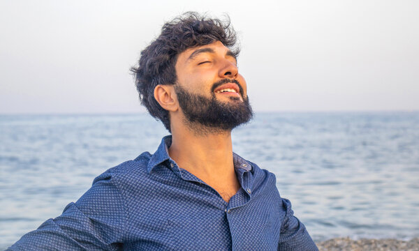 Happy Young Man Deep Breathing Fresh Air On The Beach