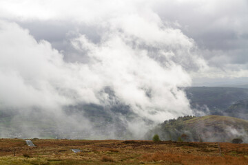 Dramatic Water vapour mist steam rising from hill and wood after rain storm.