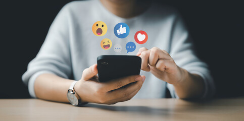 Women use smart phone to play on social media. Social Distancing, Working From Home concept. The concept of living on and playing media communication. Chat with friends and send emotion icons.