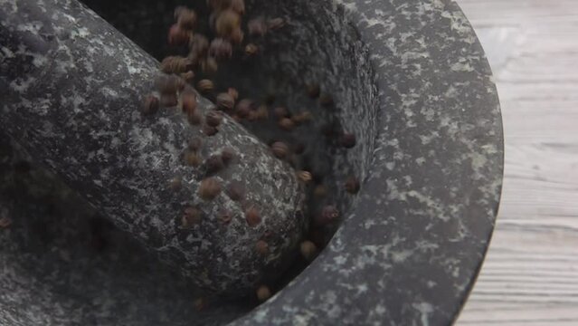 Black pepper poured into a mortar
