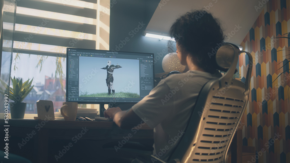 Poster male 3d designer sitting at the table at home and making animation for video game character, using m