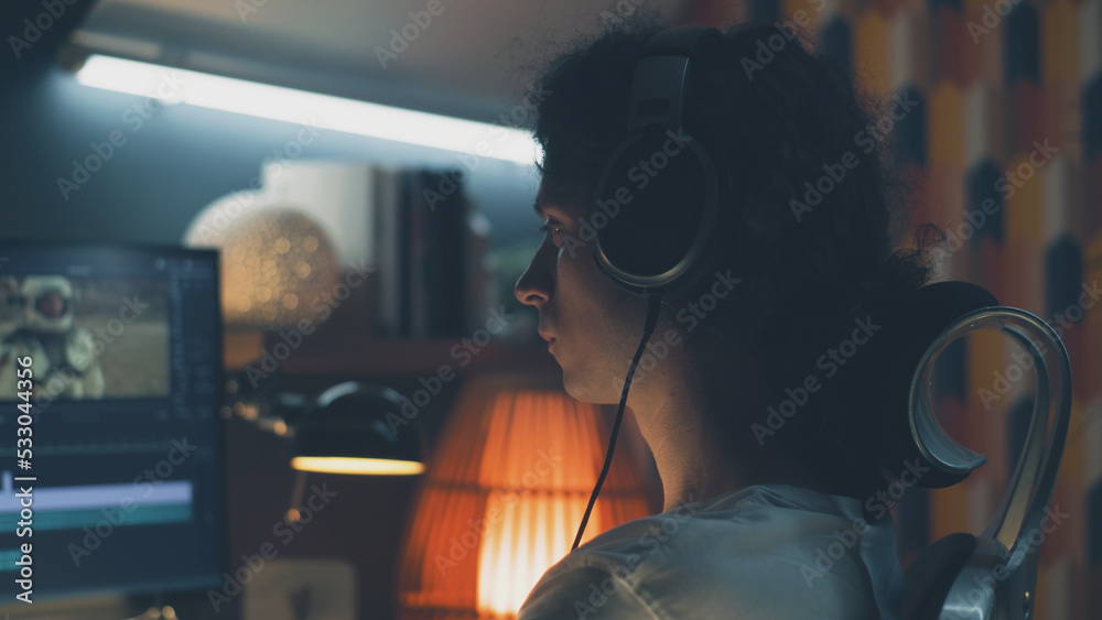 Aufkleber man in headset editing video with astronauts for client in program on personal computer while workin