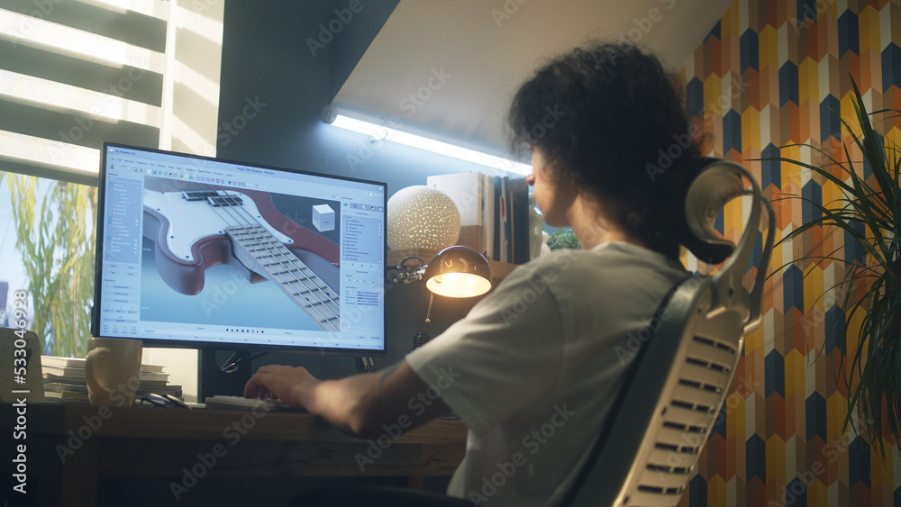 Poster Young guy creating 3D prototype of guitar using modern personal computer and 3D modeling program while working remotely from home