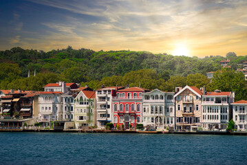 View from the sea of the green mountains of the asian side of Bosphorus strait, with traditional houses and dense trees in a summer day before sunset