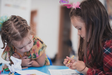 Creative kids sitting in a preschool institution, draw and have fun while they get an education