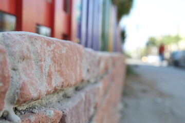 Rainbow colored fences on a tiny brick wall