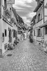 scenic small road with half timbered houses in the historic village of Eguisheim in the Alsace region