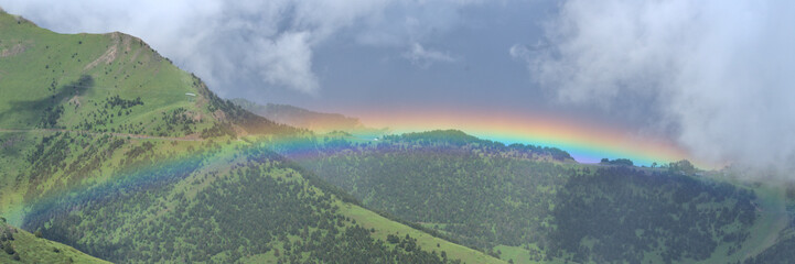Mountain Landcape in Andorra during spring season ; bright beautiful rainbow in a valley - obrazy, fototapety, plakaty