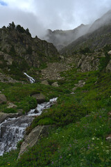 Fototapeta premium Wild Landcape in Andorra during spring season : water spring flowing down the mountains during foggy morning