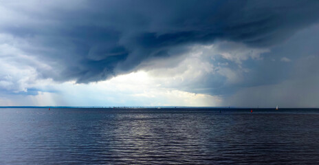Beautiful colorful sky with an approaching storm, panoramic view. Sea, dark clouds in the sky, huge...