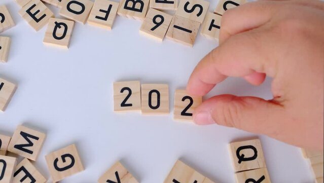 close-up of year change calendar with wood cube block tact 2023 on a light table, business concept, last quarter deadline, leave the past, plan for the future