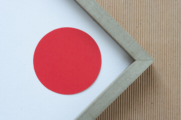 red circle inside a frame with a white ground on corrugated paper
